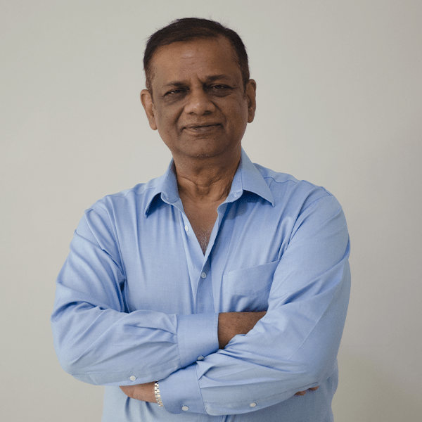 Professional headshot of Mani Agrawal, CEO FMG Health Sciences in a light blue shirt standing with folded arms. About us section