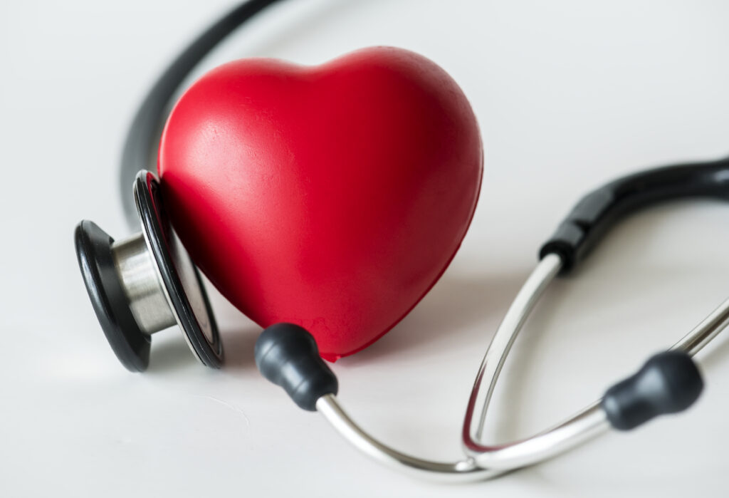 Red heart with a stethoscope symbolizing cardiovascular health, heart disease risk factors, and heart function monitoring
