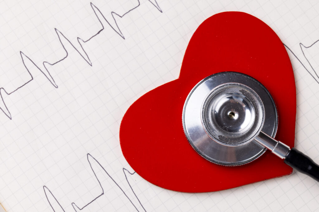 Heart health concept: stethoscope on a red heart with ECG tracing, suggesting cardiovascular workload and resilience.