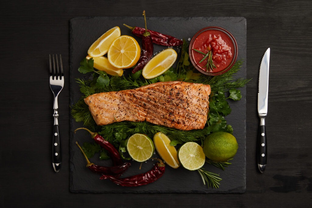 Balanced meal with salmon, vegetables, and healthy fats, representing dietary choices that help stabilize blood sugar and support arterial health.