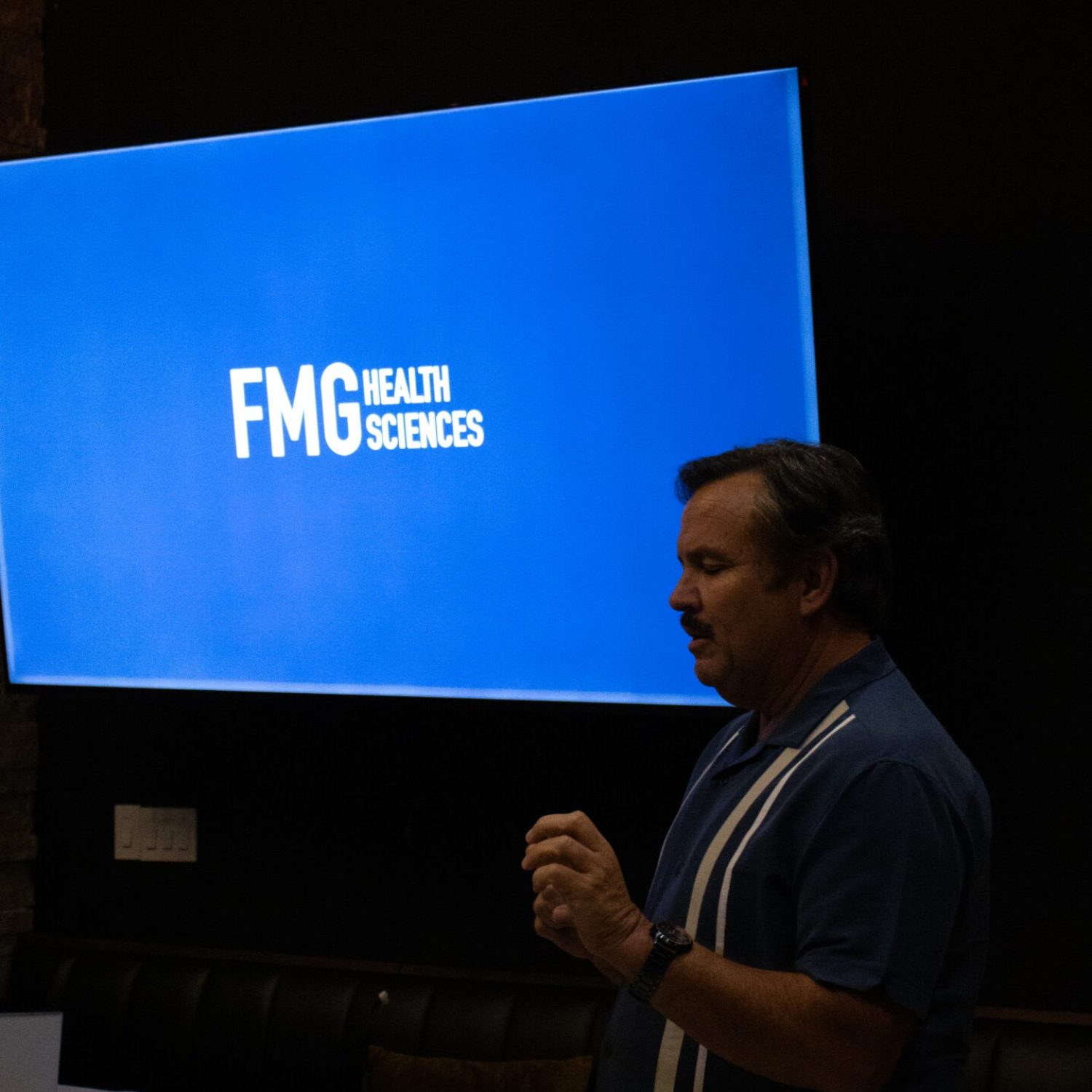 FMG Health Sciences presentation during Mitozz Events, featuring a speaker discussing mitochondrial health innovations.